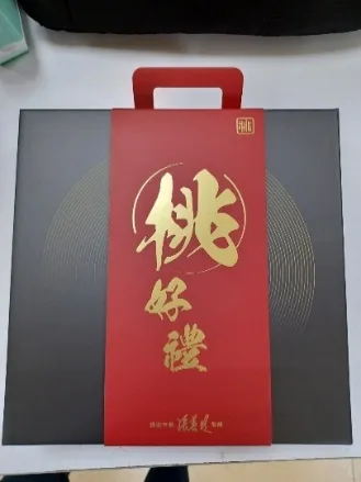 深灰色手提禮盒，中央紅色長條書腰印有金色「桃好禮」三字