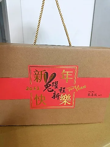 牛皮紙禮盒，繫著紅色書腰，上印金色「新年快樂」與「兔躍程新 2023」字樣及市長署名