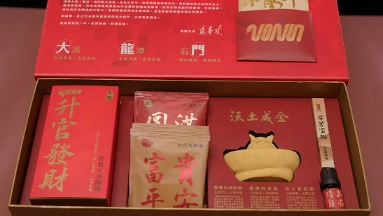打開的紅色禮盒俯拍，盒內放著紅色紙盒、茶包、元寶造型香氛座與線香，盒蓋內側印有大溪、龍潭、石門三地介紹